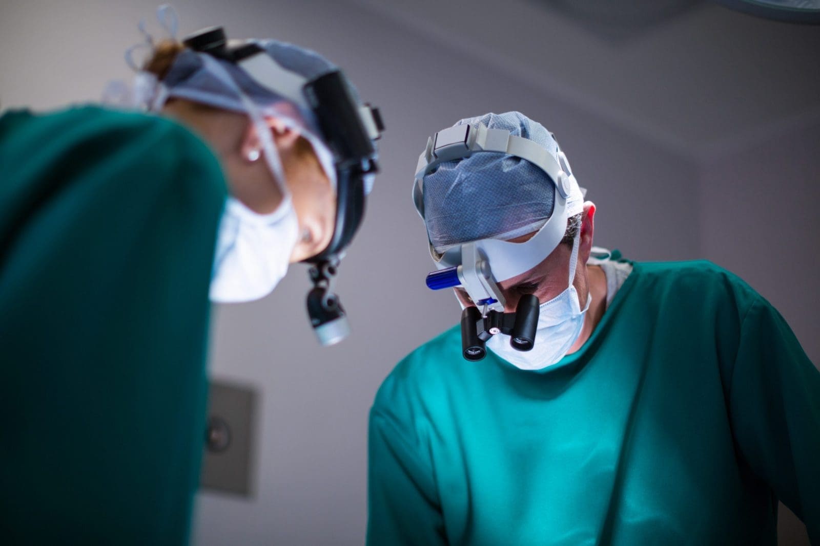 Surgeons wearing surgical loupes while performing an operation
